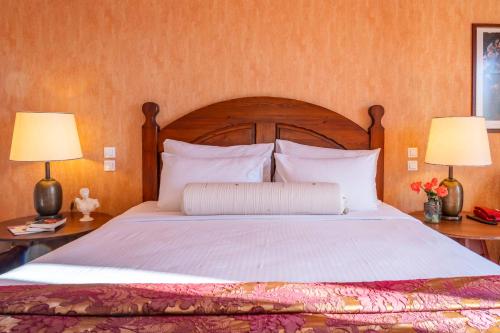 Wooden bed headboard with white linen and bedside lamps